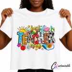 White T-shirt with a colourful “Best Teacher Ever” DTF transfer design featuring school supplies, an apple, pencils, books, stars, and bright classroom-themed illustrations.