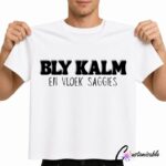White T-shirt with black Afrikaans text reading “Bly Kalm En Vloek Saggies” in bold and handwritten-style typography.