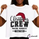 White T-shirt with “Christmas Crew Making Memories Together” DTF transfer design featuring black lettering, a red Santa hat, and festive accents.