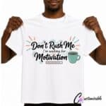 White T-shirt with “Don’t Rush Me I’m Waiting For Motivation” DTF transfer design featuring script lettering, a coffee cup, and a small loading bar.