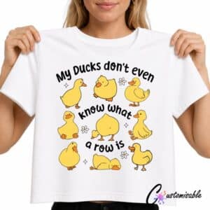 White T-shirt with “My Ducks Don’t Even Know What A Row Is” DTF transfer design featuring cute yellow duck illustrations and small daisy accents.