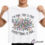 White T-shirt with “I’m Fine This Is Fine Everything Is Fine” DTF transfer design featuring tangled Christmas lights and colourful bulbs.