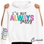 White hoodie with colourful “I’m Not Always Sassy” DTF transfer design and matching sleeve text reading “Sometimes I Sleep.”